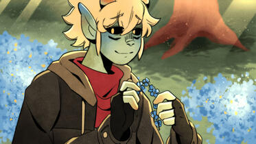 mychael, with a soft smile and blush on his face, halfway through making a flower crown.